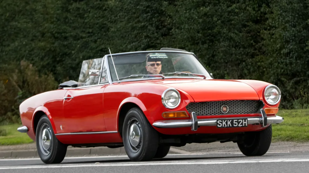 Bicester,Oxon.,UK - Oct 8th 2023: 1969 red Fiat 124 classic car driving on an English country road.