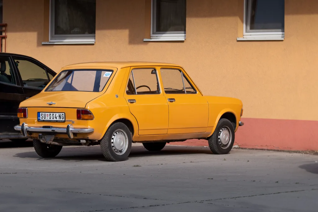 Classic Yugoslaviancar Zastava 101 (also known as Yugo Skala 55 - licensed Yugoslavian FIAT 128) is Parked in Subotica, Serbia 13.05.2023 back-side view, orange color.