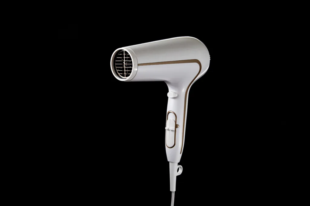 Professional stylish hairdryer isolated over a black background. White Ionic Hair Dryer with Hair Care Tool.