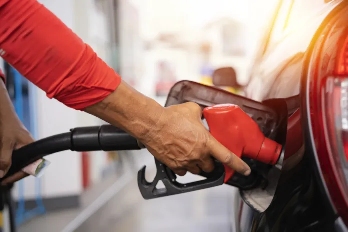 Refueling the car at a gas station fuel pump. Man driver hand refilling and pumping gasoline oil the car with fuel at he refuel station. Car refueling on petrol station. Fuel pump at station