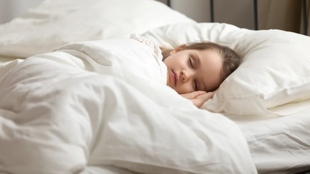 Calm adorable little daughter take day nap. Tranquil preschool child girl covered with white fresh duvet lying in bed comfortable mattress on bedroom. Healthy enough sleeping, zzz, good night, concept