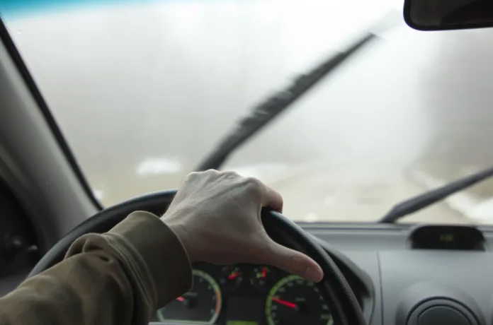 Cropped Hand of Car´s Driver in Bad Foggy Conditions