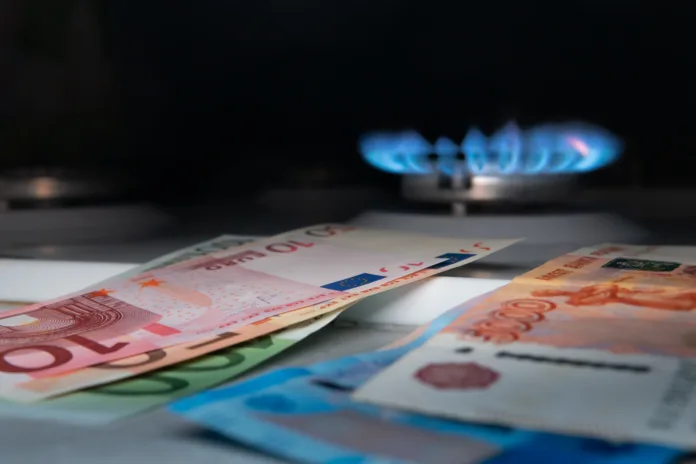 Euro banknotes against the background of Russian banknotes and a gas burner. Gas crisis concept. Cash. High prices for natural resources. Tongues of flame. Public debt. Selective fokus