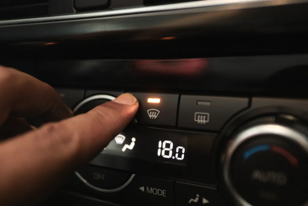 Windshield Defogger Icon on Car. hand pressing the defogger button to remove the fog on the windshield