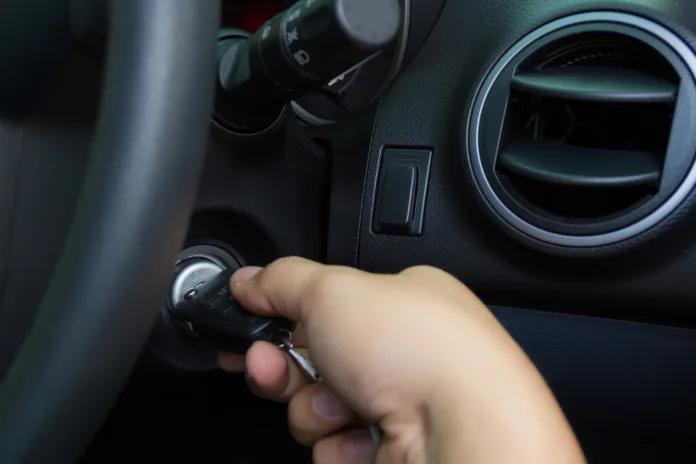 man starting the car with key.