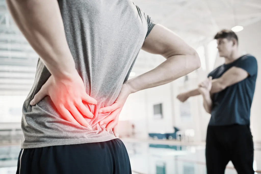 Back pain, red and person hands for swimming training, exercise and workout with sports risk or spine problem. Injury, overlay and athlete, swimmer or people for medical check or emergency by pool