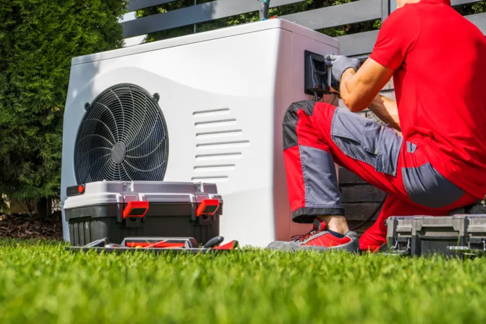 Backyard Swimming Pool Heat Pump Maintenance Performed by Caucasian HVAC Technician. Pool Heating Modern Technologies.