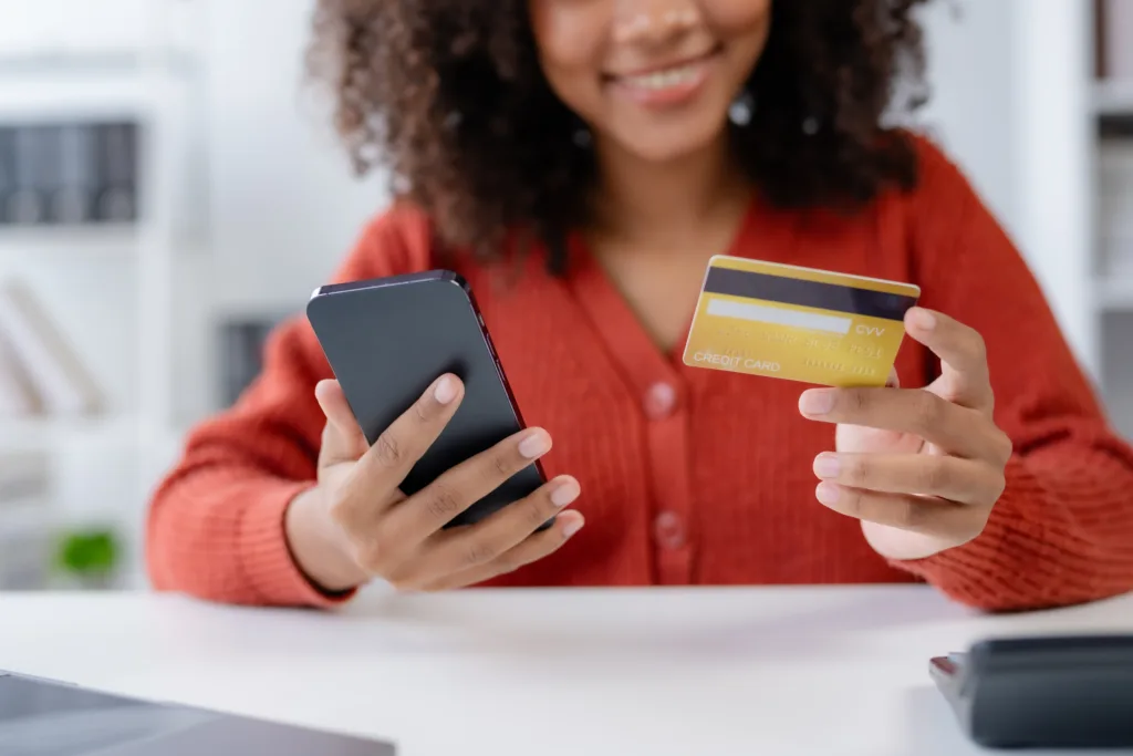 Young business woman is using smartphone for online shopping and using credit card for payment through banking application for online shopping.