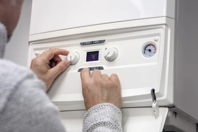 Adjusting thermostat setting on domestic home heating system central heating boiler