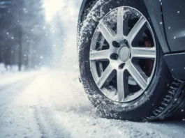 Car on winter tires drives through a snow-covered road. Seasonal change of tires from summer to winter