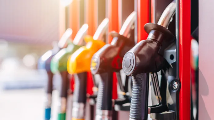 Diesel petrol fuel pistols nozzle refill at gas station. Fuel price crisis impact fuel cost in transport business and Travel energy consumption rise in petroleum gasoline station service production.