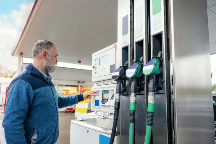 A man at the gas station filling the tank of his car with diesel to the top level before a long journey as fuel prices is going up