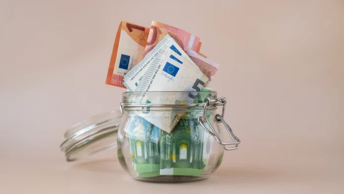 Euro cash banknote in glass jar on beige background. Saving money concept crisis and inflation Consumption and economy Collecting money. Tips. Extra money, passive